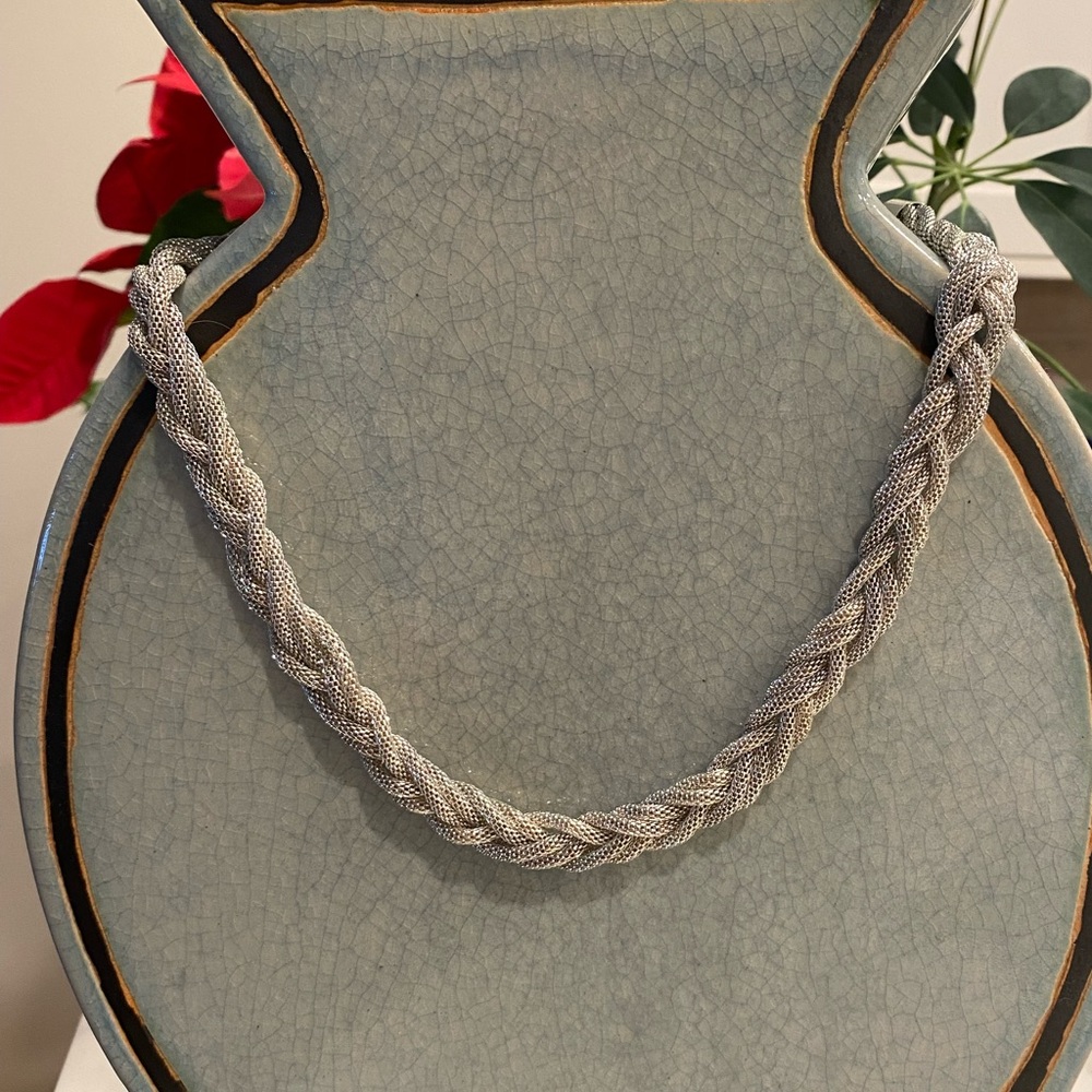 Cute Necklace Silver-tone braided, lightweight. Lays flat. Looks good.